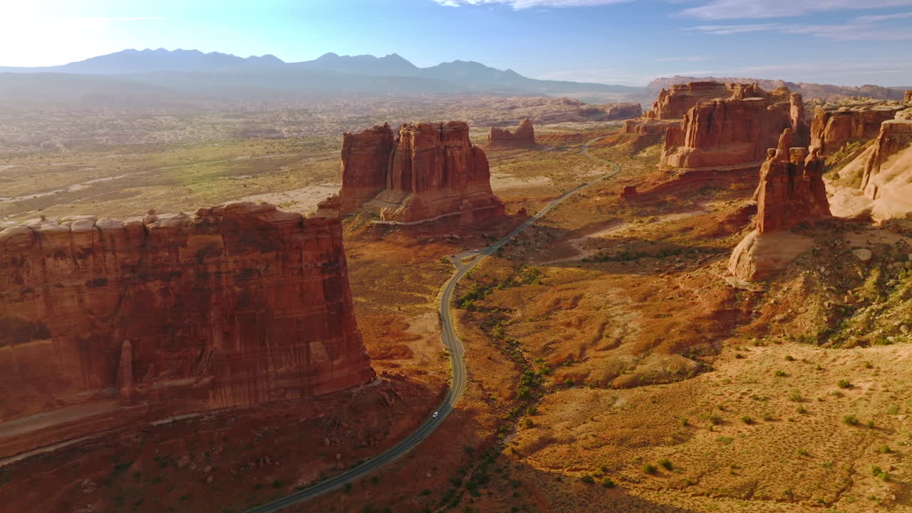 Separate mount standing lonely on the desert land. Motorway going among the rocks of amazing canyons in Utah, USA.
