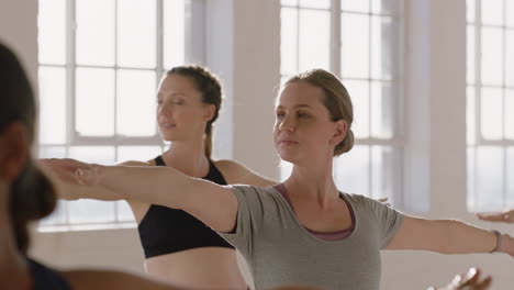 young pregnant caucasian woman in yoga class practicing warrior pose enjoying healthy lifestyle group exercising in fitness studio at sunrise