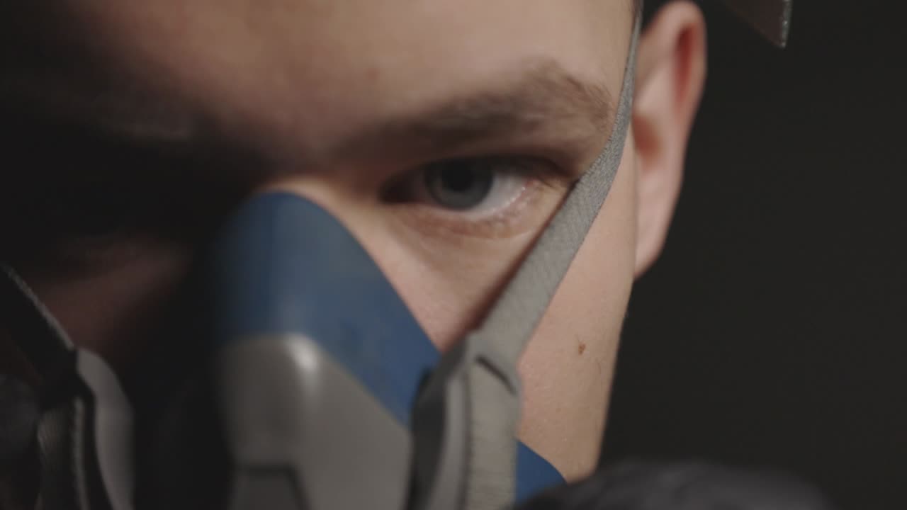Closeup View Of A Man Removing His Respirator - Closeup Shot