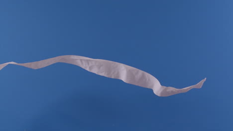 a toilet paper roll is seen flying through the air in front of a blue screen