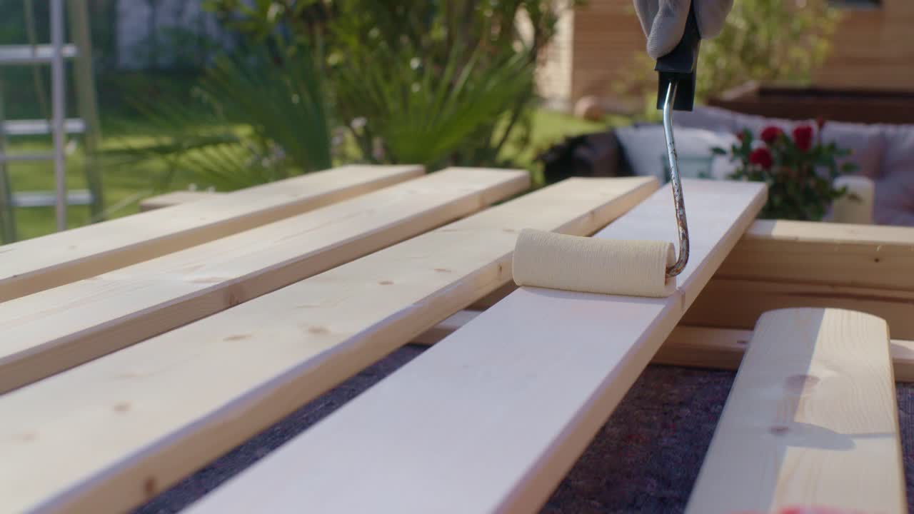 L'artigiano vernicia il legno di bianco