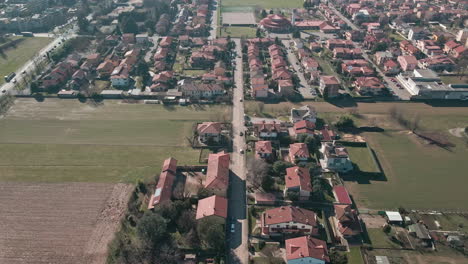 Volando-Sobre-Villas-Adosadas-Rodeadas-De-Campos-Campesinos-Durante-Un-Día-Soleado-En-Italia---Toma-Aérea-De-Drones