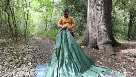 cool man with sunglasses gets angry when fails to assemble tent in forest