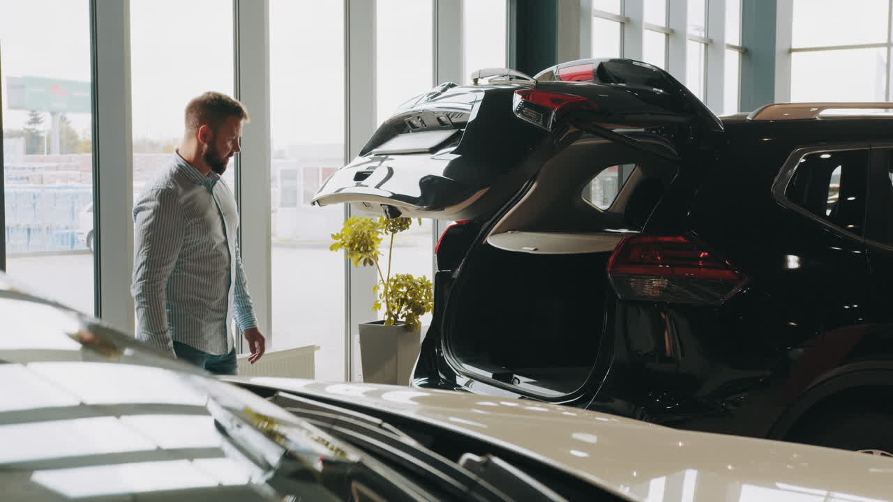 자동차 전시실에서 suv를 보는 남자