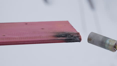 burning a pink plastic sheet with a torch