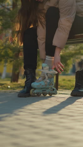 un primer plano capturando a una persona en un parque con una patineta azul claro mientras la otra pierna todavía está en una bota negra, preparándose para cambiar de caminar a patinar