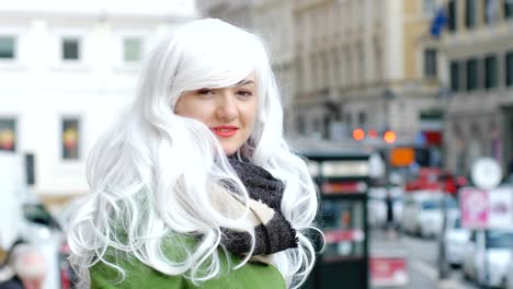 smiling funny young woman with white wig in the street