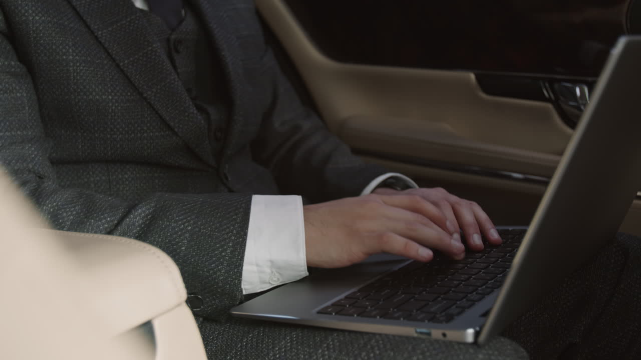 Unrecognizable Person Using Laptop in Car