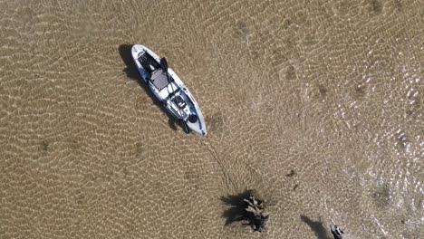 Vista-única-De-Un-Perro-Corriendo-Y-Jugando-Alrededor-De-Un-Kayak-Anclado-En-Aguas-Tropicales-Claras