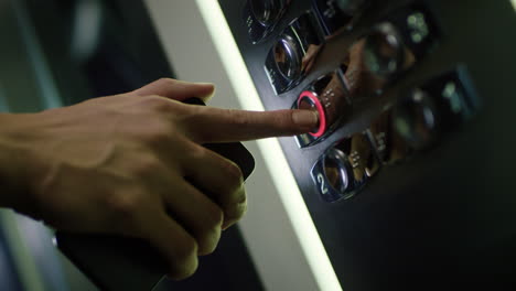 Male-hand-pushing-button-with-number-of-floor-in-elevator.-Human-finger-pressing