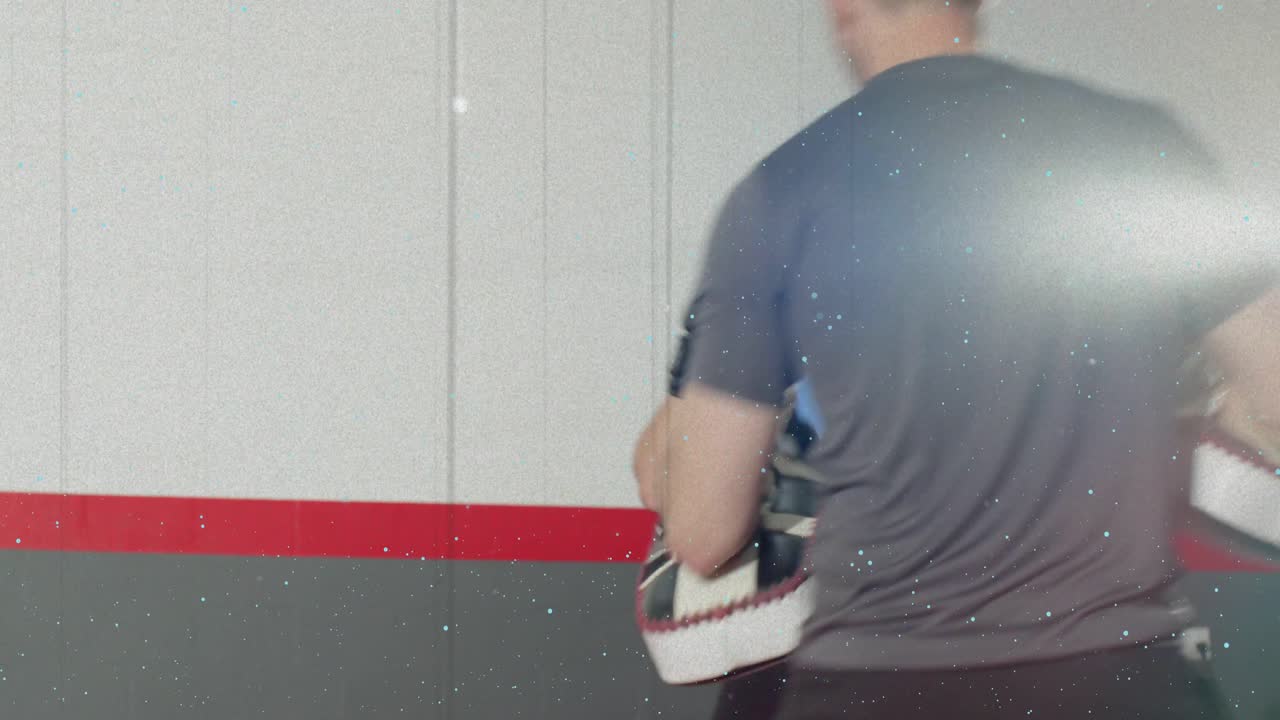 Coach signaling target, trainee practicing boxing combos in gym, holding focus mitts guiding speed