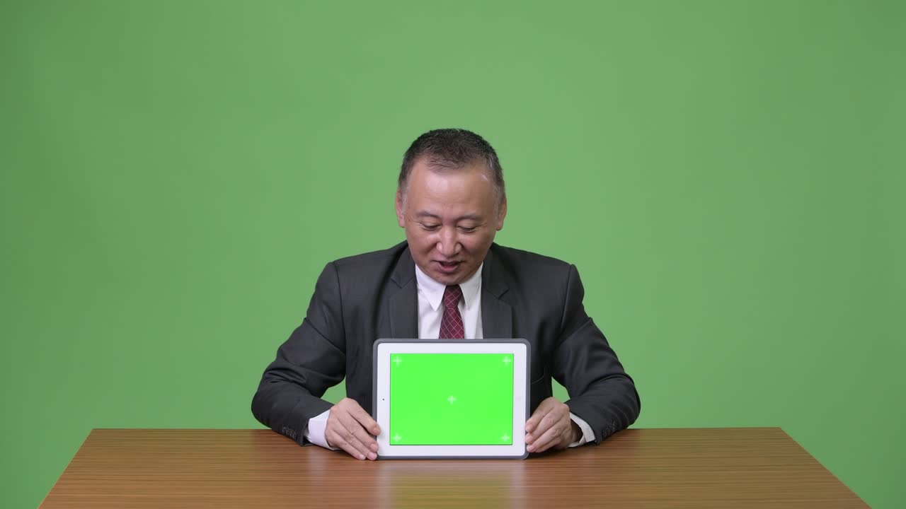 디지털 태블릿을 보여주는 성숙한 일본 사업가