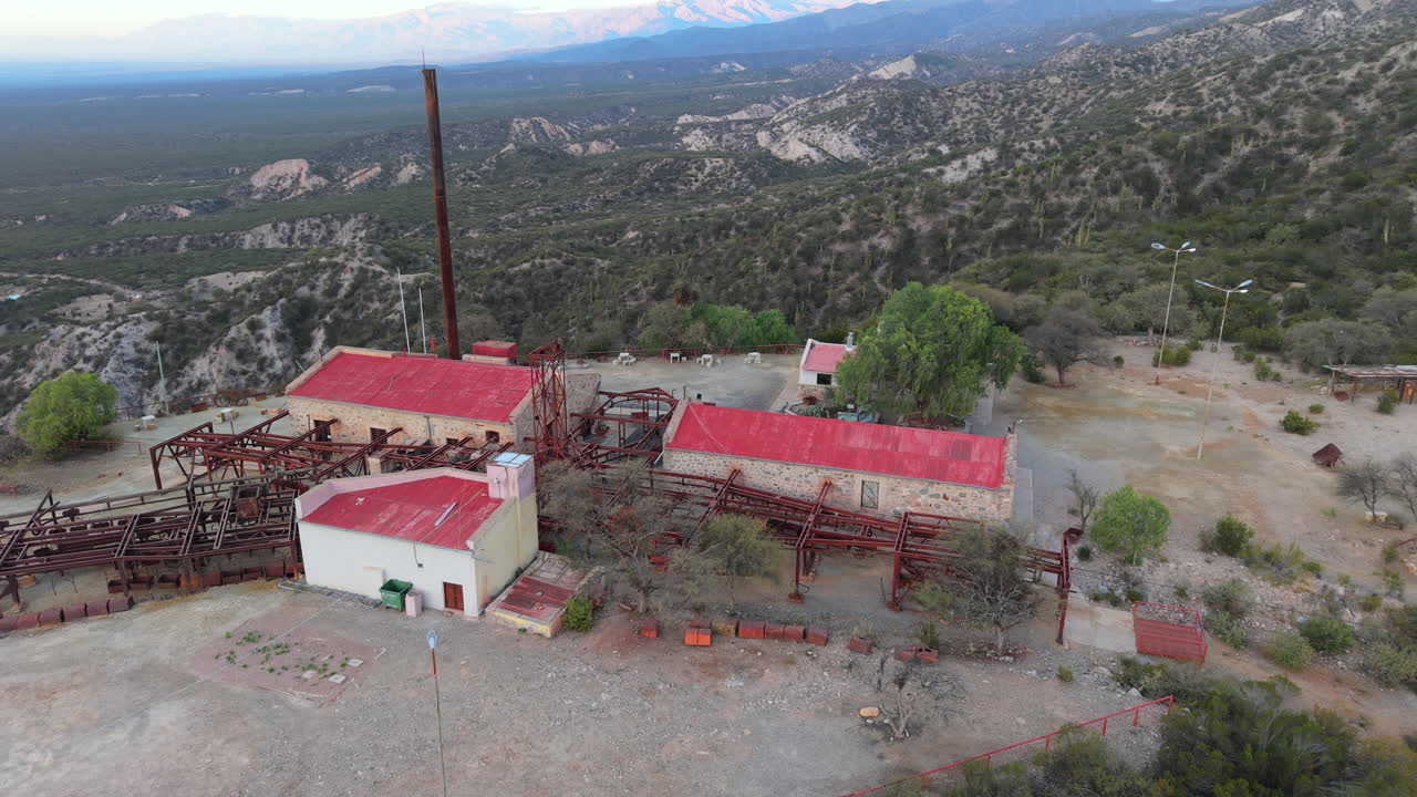 Historic hotel and mining ruins of Estación 2 Cable Carril with red roofs and tall chimney in the mountains, Chilecito, La Rioja, Argentina