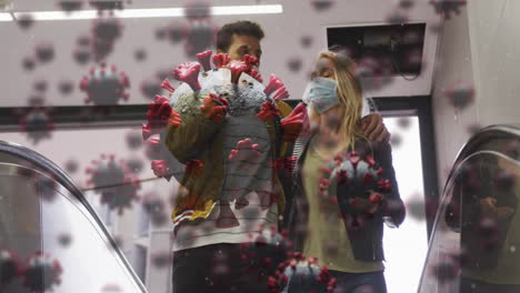 animation of virus cells over caucasian couple wearing face masks walking in street