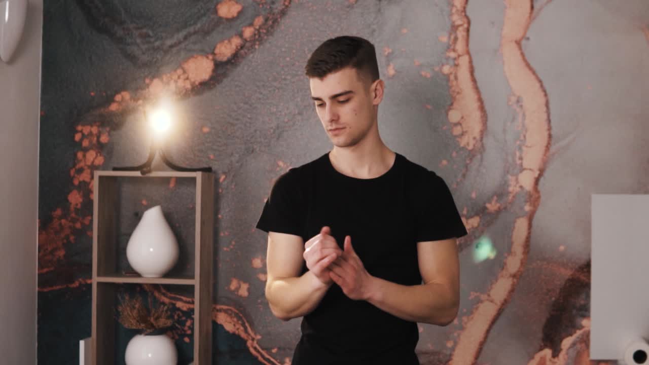 아름다운 마사지실에서 손으로 오일을 문지르는 젊은 남성 마사지사의 초상화