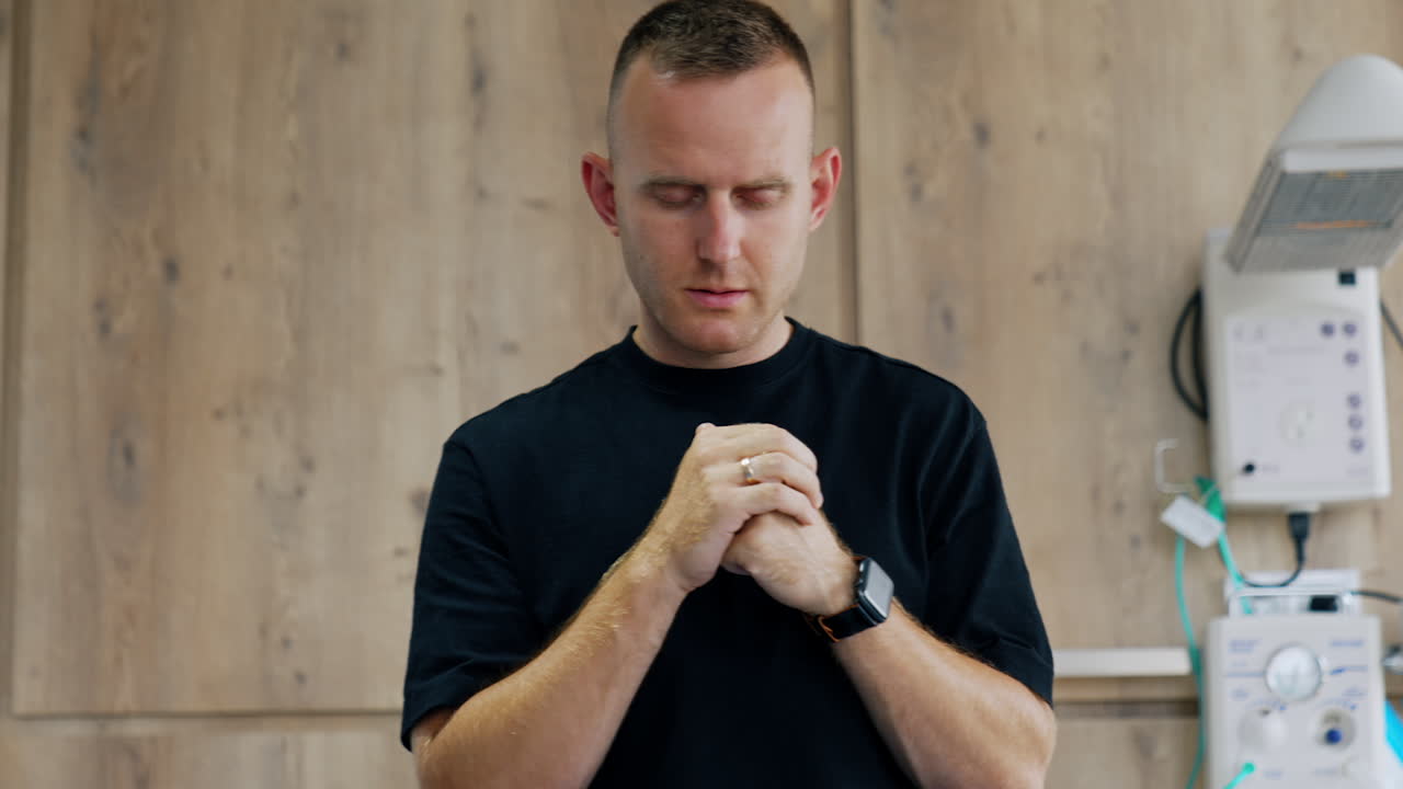 Mid-aged Caucasian man wearing black t-shirt is nervous. Husband is worrying about his wife delivering a baby.