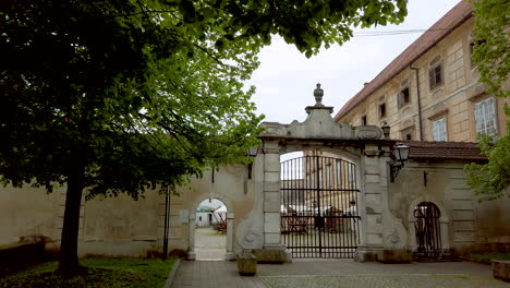 Palacio-Barroco-Renacentista-En-La-Ciudad-Medieval-Europea,-Castillo-En-Slovenska-Bistrica,-Eslovenia,-Lenta-Panorámica-De-La-Entrada-Principal-Con-Puertas-De-Hierro