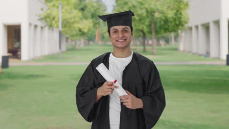 Happy-Indian-college-student-standing-with-degree