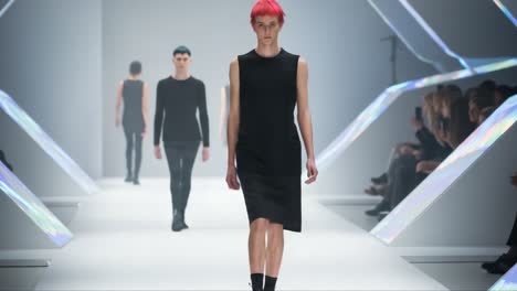 high fashion showcase featuring male models with edgy hairstyles displaying a contemporary collection on a minimalist runway with futuristic elements