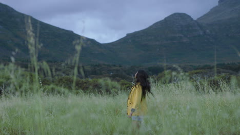 lively-young-indian-woman-hiker-jumping-celebrating-excited-enjoying-independent-travel-adventure-achievement-in-grass-field-countryside-landscape