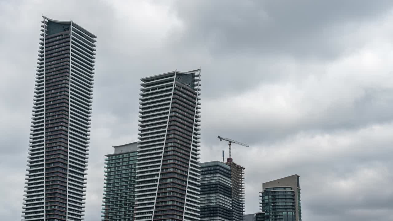 nubes sobre rascacielos y construcción en toronto, tilt up timelapse