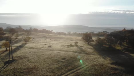 Spektakulärer-Blick-über-Das-Hochland-In-Richtung-Sonne,-See-Und-Hügel-Im-Hintergrund