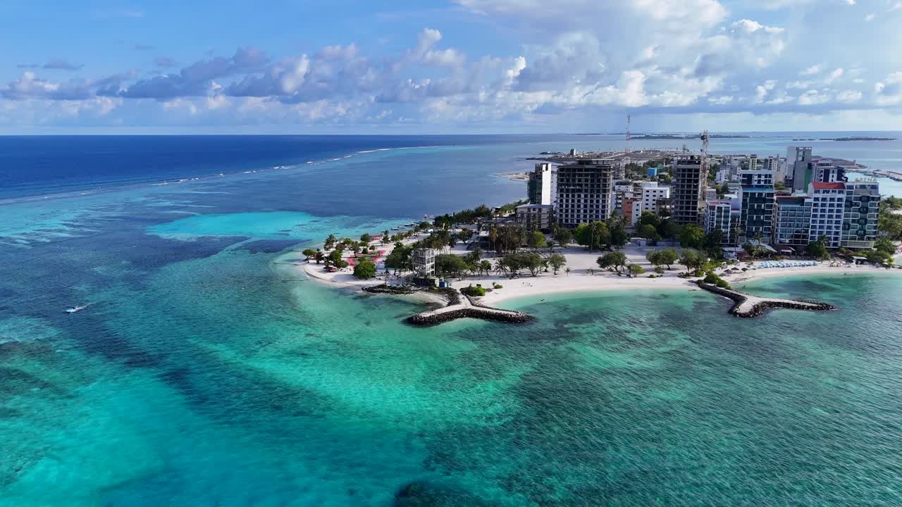 Vista aerea dell'isola di Maafushi e della barriera corallina, Maldive, costa della laguna turchese.