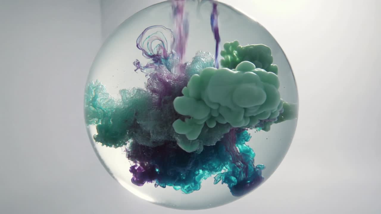 Entering magenta and blue droplets into spherical tank in studio, showing dye mixing