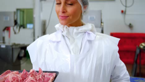 Female-butcher-holding-a-tray-of-raw-meat