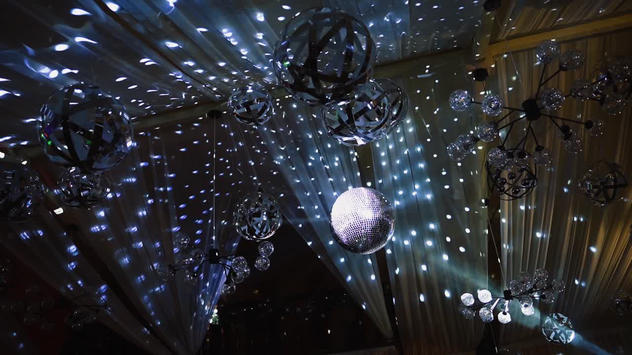 Nightclub ceiling with many shining balls. Disco ball shimmering and spinning on the glittering background.