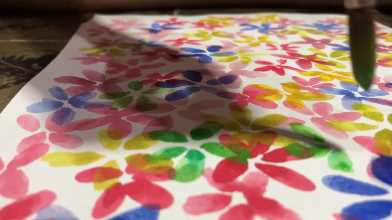 Close up learning painting colorful abstract flowers using watercolors and brushes on paper