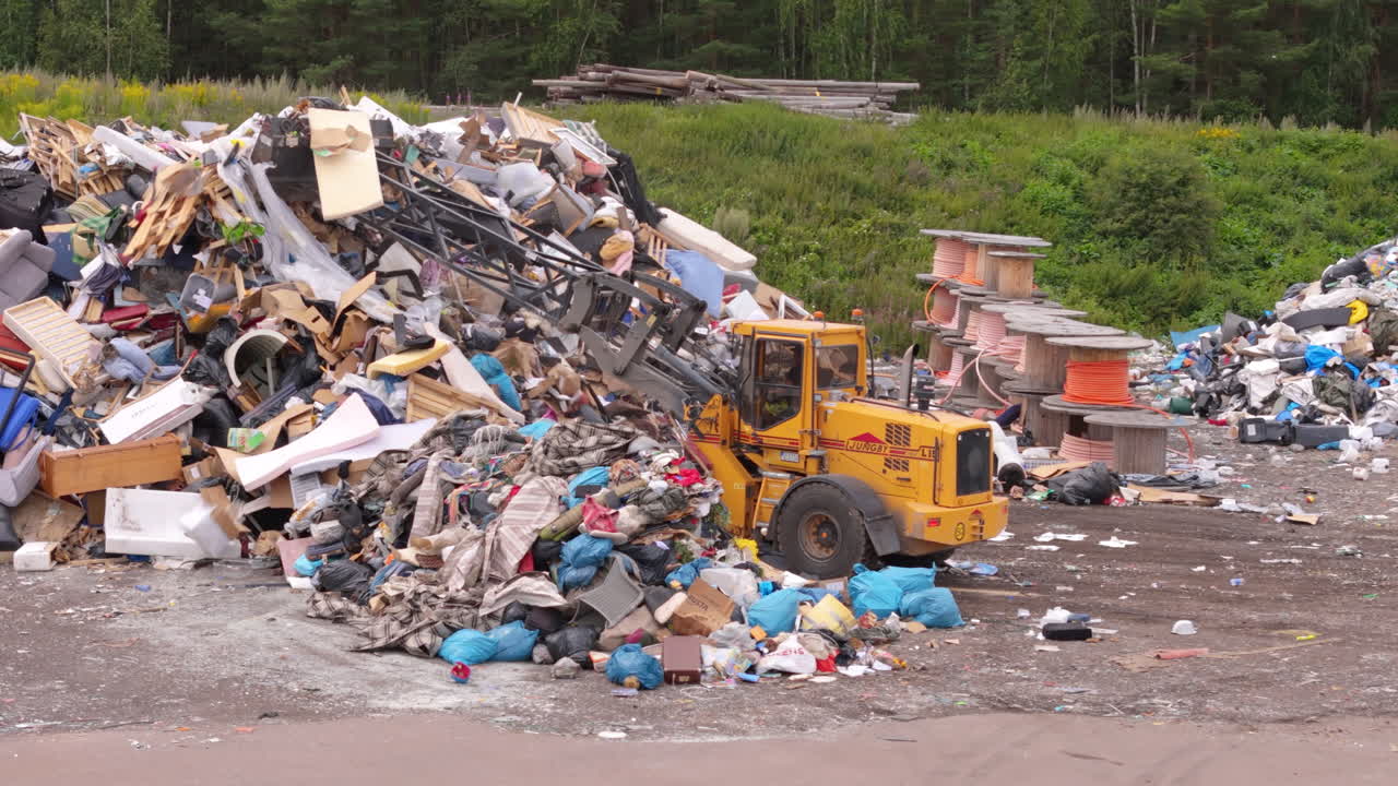 Dozer push trash onto pile to be incinerated for electricity production, aerial