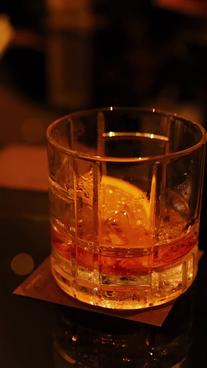 Bicchiere di whisky e fiori su un tavolo da bar
