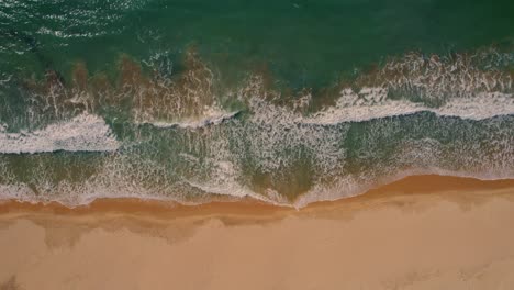 Vista-Aérea-De-Arriba-Hacia-Abajo-De-Las-Olas-Rompiendo-En-Una-Playa-De-Arena-Blanca-En-Tarifa,-España