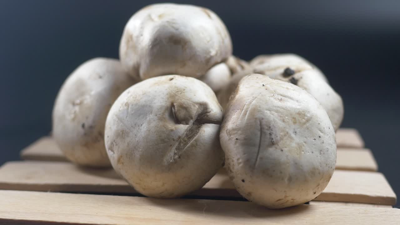 una pila de setas blancas en una caja de madera.
