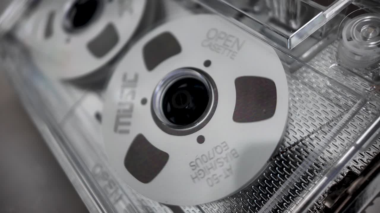 Montrant la nostalgie et le renouveau audio analogique avec un gros plan de bobines de cassette audio musicales en rotation