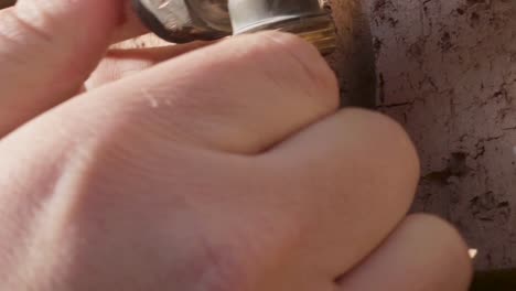 static shot of a leaking tap being fixed by a man