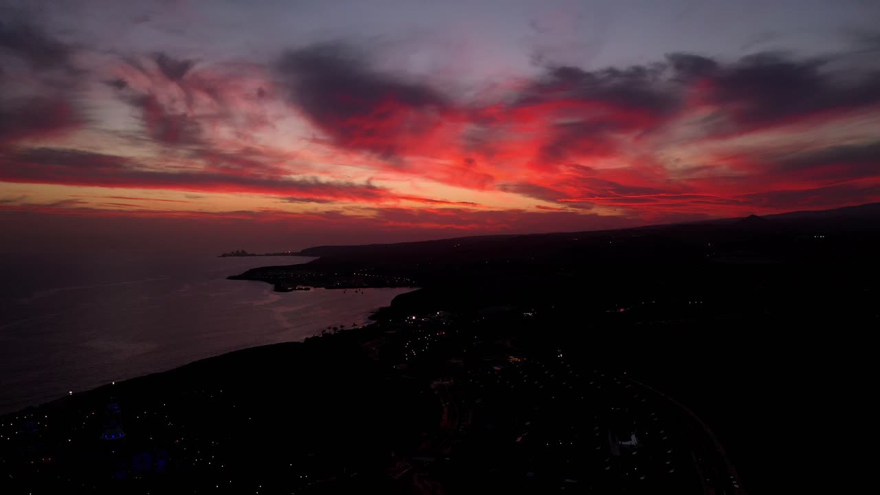 дрон лас пальмас гран канария в сумерках с огненно-вибрирующими красными облаками, аэрофотосъемка на море