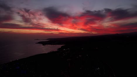 drone of las palmas gran canaria at nightfall with fiery vibrant red clouds, aerial at sea