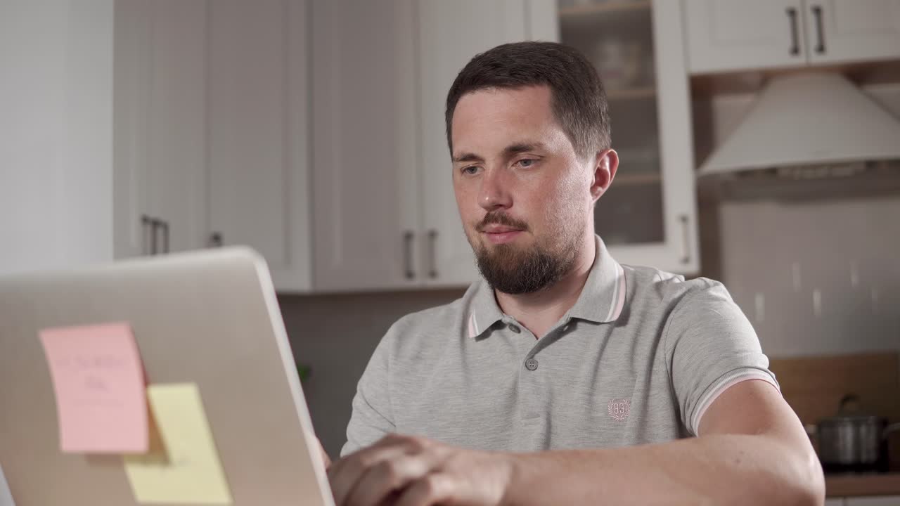 hombre trabajando en una computadora portátil en la cocina