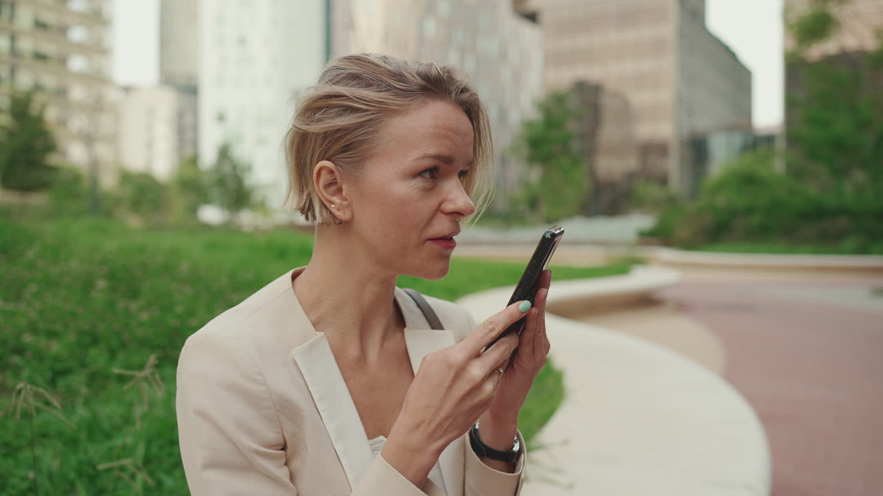 Mulher de negócios usando o celular ao ar livre em um ambiente urbano