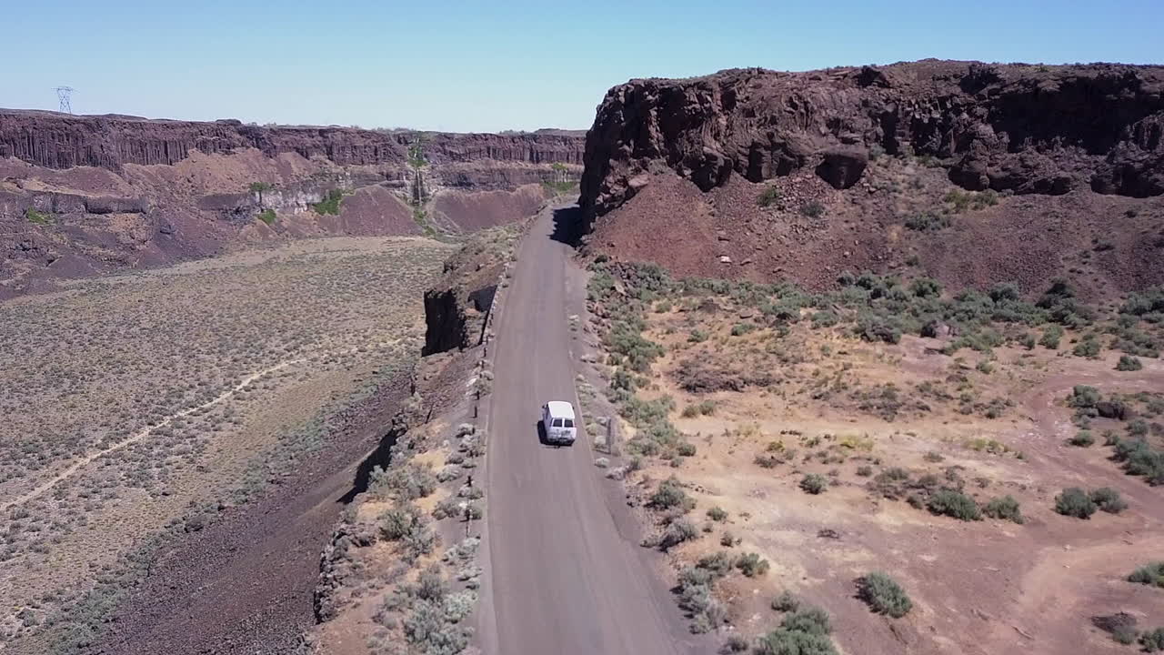 la antena de frenchman coulee sigue a la furgoneta que conduce por una carretera panorámica fuera del cañón.