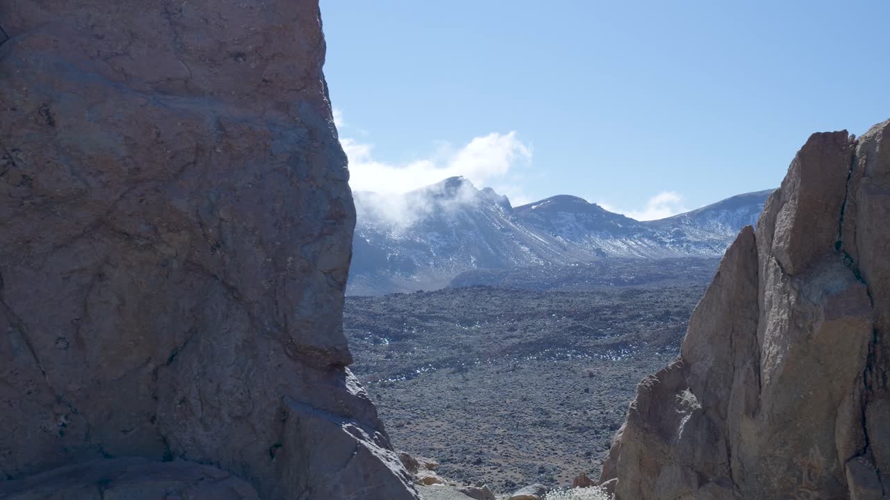 Nuvole che si Muovono su Montagne Vulcaniche Innevate e Paesaggio Roccioso