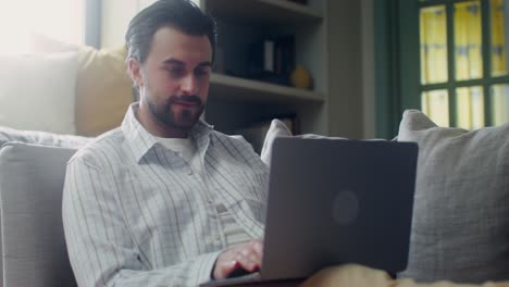 hombre trabajando en una computadora portátil en casa