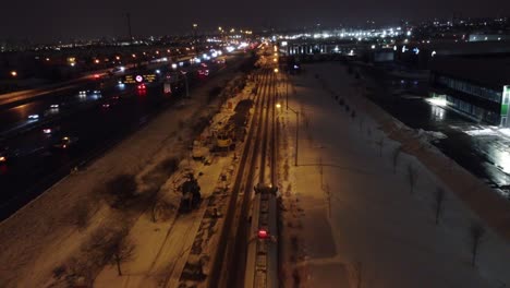 aerial view of tank truck navigating on the the road through snow at night in toronto, canada