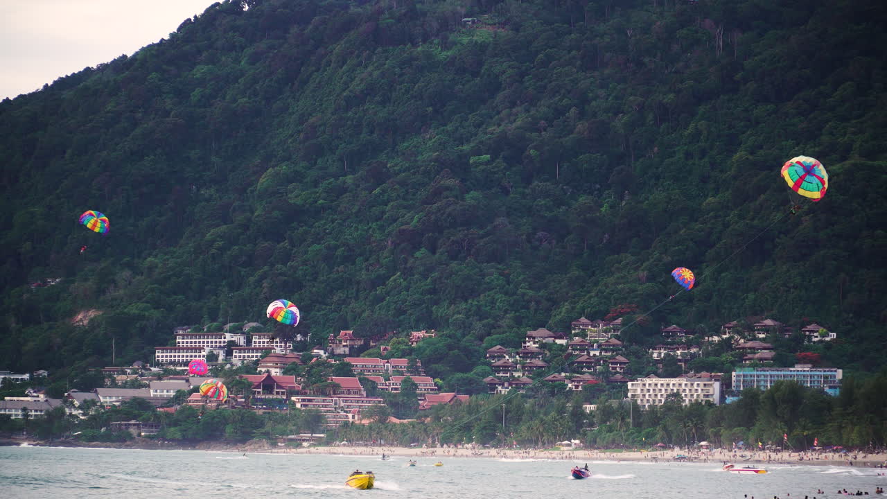 Cena na Praia de Patong com parasailing colorido, Phuket, Tailândia.