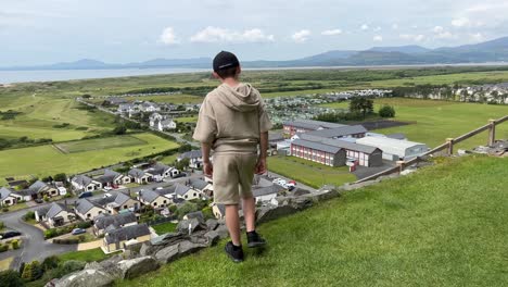 young boy looking down onto harlech from harlech castle