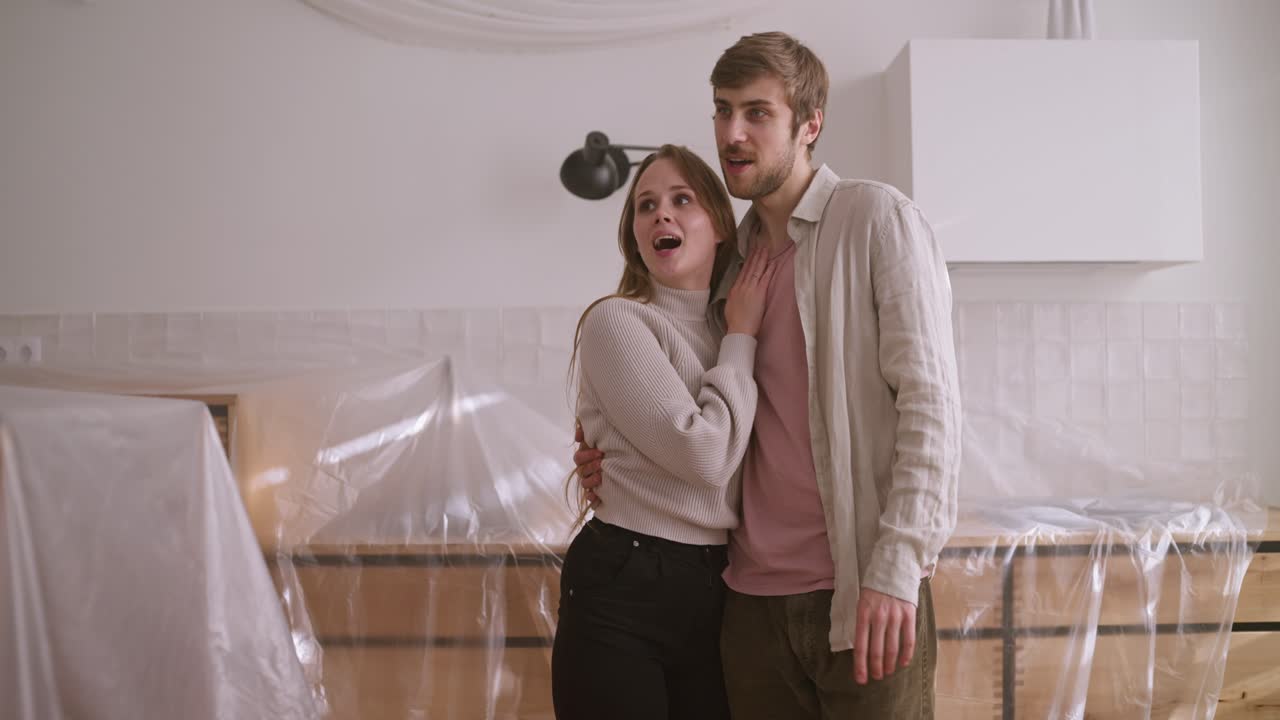 coppia che ispeziona con entusiasmo la nuova ristrutturazione della cucina