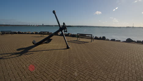 extra wide shot of an old anchor at hythe marina village with weston in background