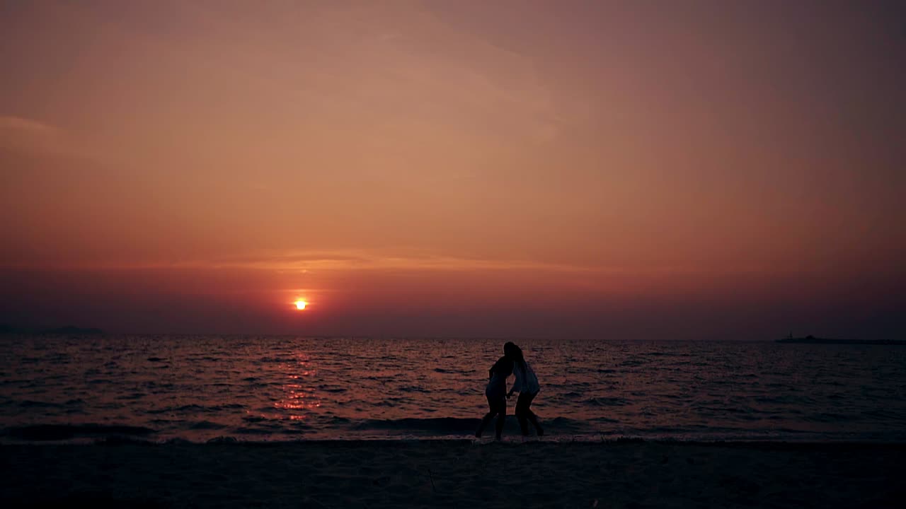 젊은이 들 은 해안 에 있는 바다 물 에서 느린 영상 으로 재미 를 느끼고 있다